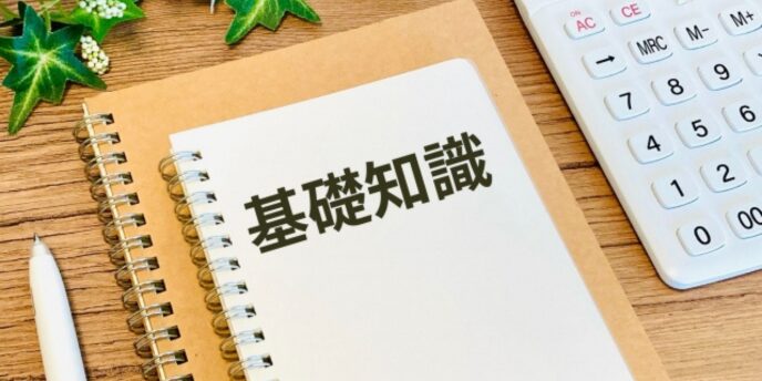 基礎知識と書かれたノートと電卓、ペンが置かれた机上のイメージ
