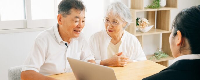 シニア夫婦が担当者とパソコンを見ながら住宅相談をしている様子