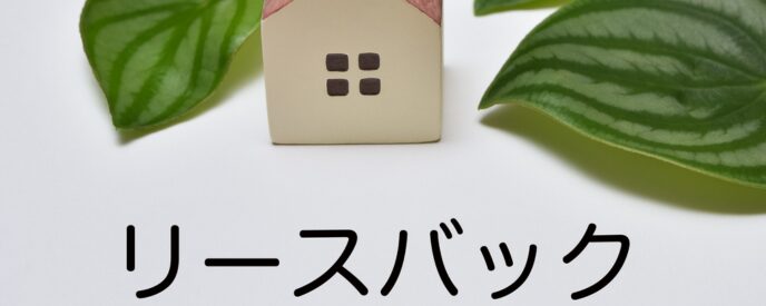 リースバックのイメージとして葉の上に置かれた家のミニチュア