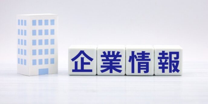 白いブロックに「企業情報」と書かれたイメージとビルの模型