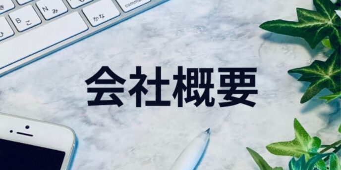 キーボードとスマートフォン、ペンに囲まれた「会社概要」の文字