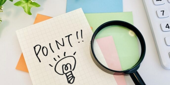 「POINT!!」と電球イラストが描かれたメモと虫眼鏡のイメージ