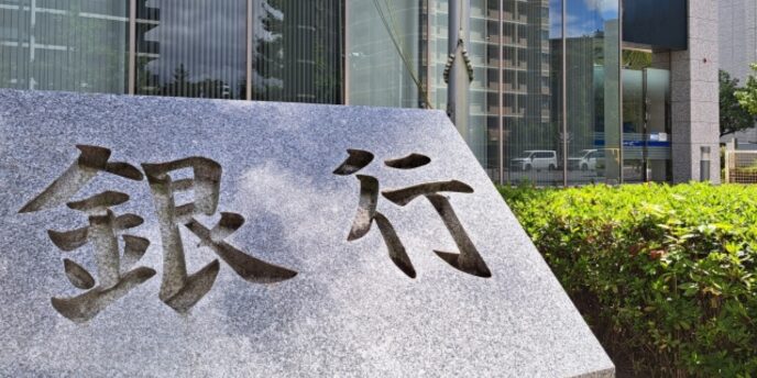 銀行の文字が刻まれた石碑と近代的なビルの外観