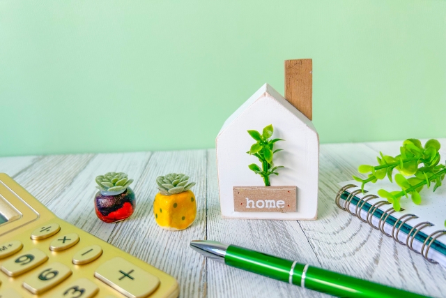 家の模型と計算機とボールペン