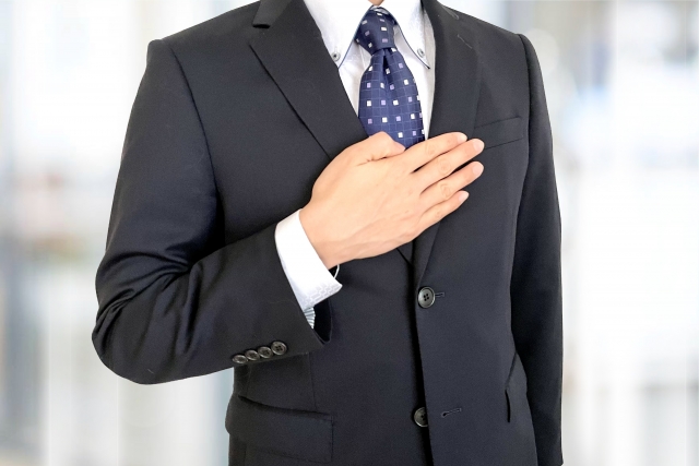 胸に手を当てるビジネスマン