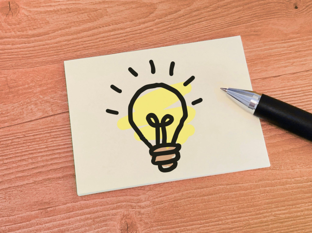 豆電球の絵が描かれている紙とペン