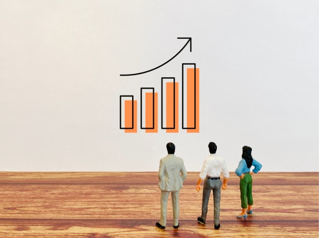 上向きのグラフを眺めるビジネスマンたち