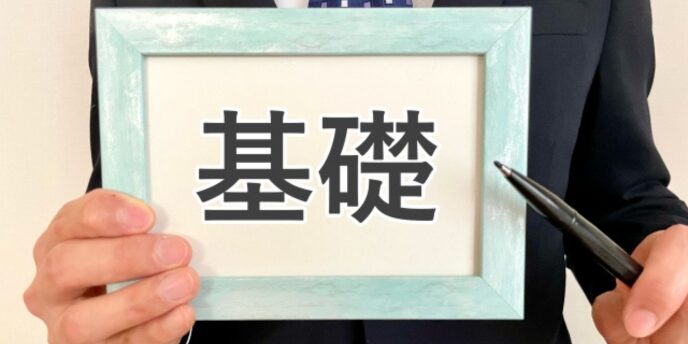 「基礎」と書かれた額縁を手に持ち、指し示すビジネスマンのイメージ
