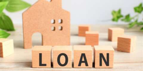 「LOAN」の文字が書かれた木のブロックと家の模型のイメージ