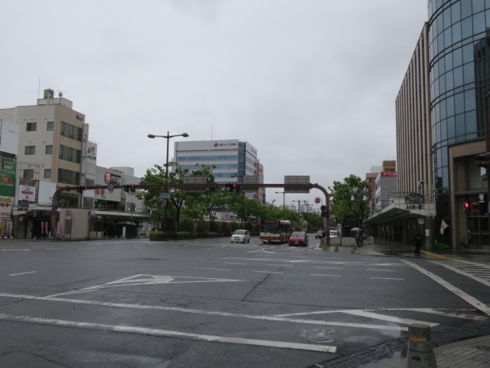 雨が降る中で交差点が広がる市街地