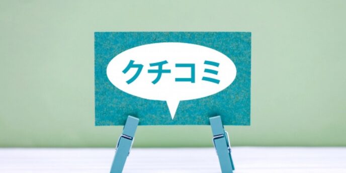 「クチコミ」と書かれた吹き出し型カードがクリップで立てられているイメージ