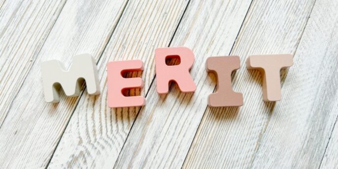木目調の明るい床に「MERIT」の立体アルファベットが並べられている