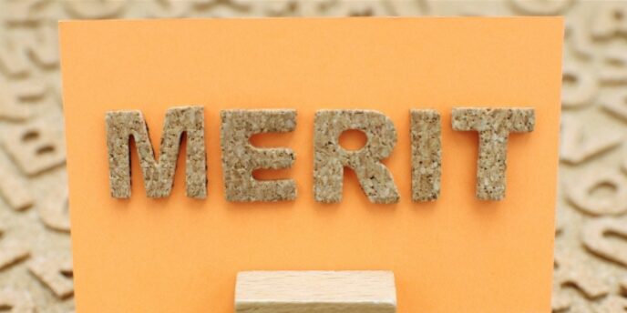 オレンジの台紙に貼られたコルク素材の「MERIT」の文字