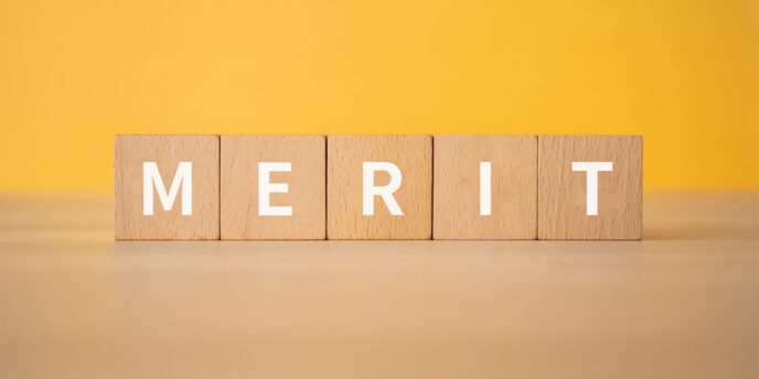 黄色い背景に「MERIT」の文字が並ぶ木製ブロック