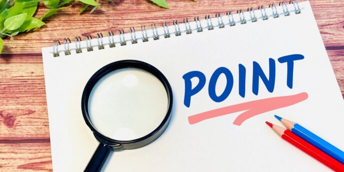 「POINT」の文字と虫眼鏡・色鉛筆で要点を強調するメモ