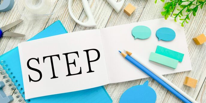 「STEP」と書かれたノートと青系文房具