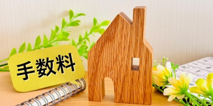 木製の家の模型と手数料の文字が書かれた札