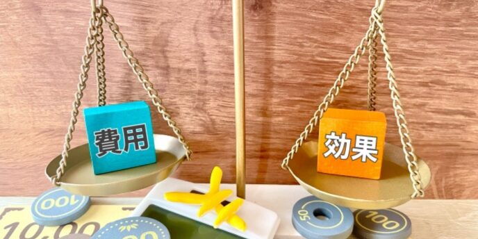 「費用」と「効果」のキューブが天秤に乗り、バランスを比較している写真。
