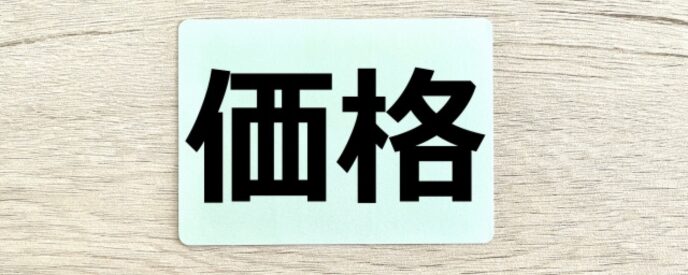 木目の背景に「価格」と書かれた札のイメージ