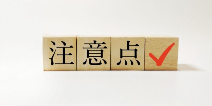 「注意点」と書かれた木のブロックと赤いチェックマークのイメージ