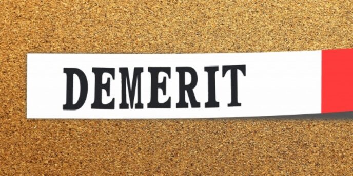 コルクボード上に配置された「DEMERIT」のラベル