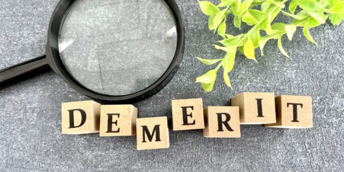 英字ブロックで「DEMERIT」と並び、虫眼鏡と植物の葉が添えられた画像