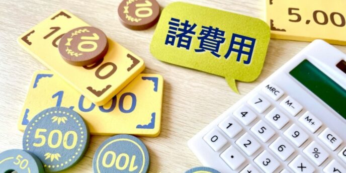 「諸費用」と書かれた吹き出しと計算機、お金を模したパーツが並んだ写真。