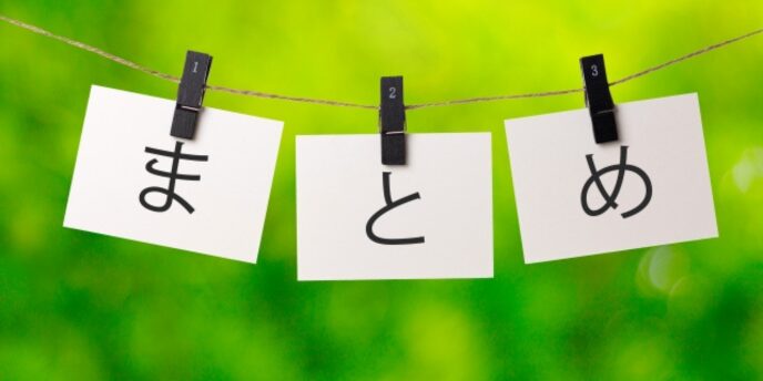 緑の背景に「まとめ」と書かれた紙が洗濯ばさみで吊るされている