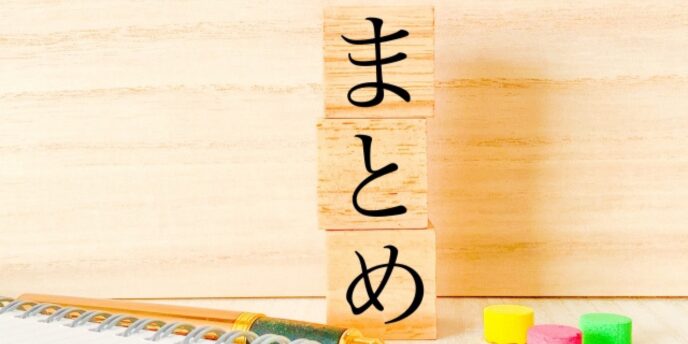 木のブロックに書かれた「まとめ」の文字とノート、消しゴムのイメージ