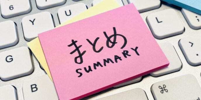 キーボードの上に置かれた「まとめ SUMMARY」と書かれたピンクの付箋