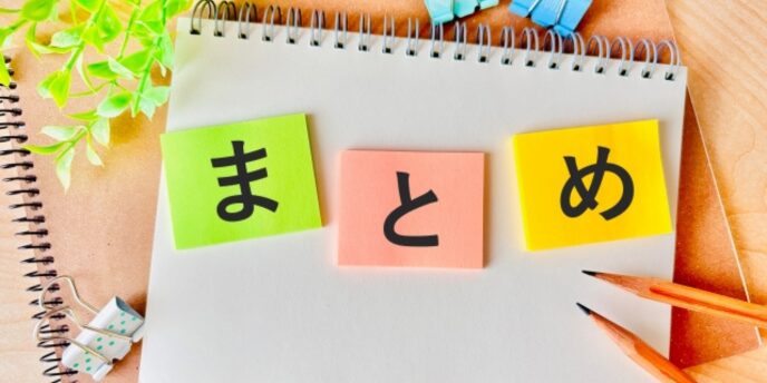 「まとめ」と書かれたメモ帳と鉛筆、付箋が置かれた写真。