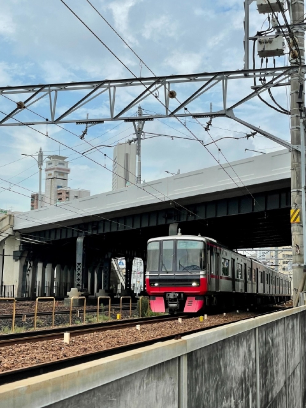 高架下を走る電車とビル街が背景にある風景