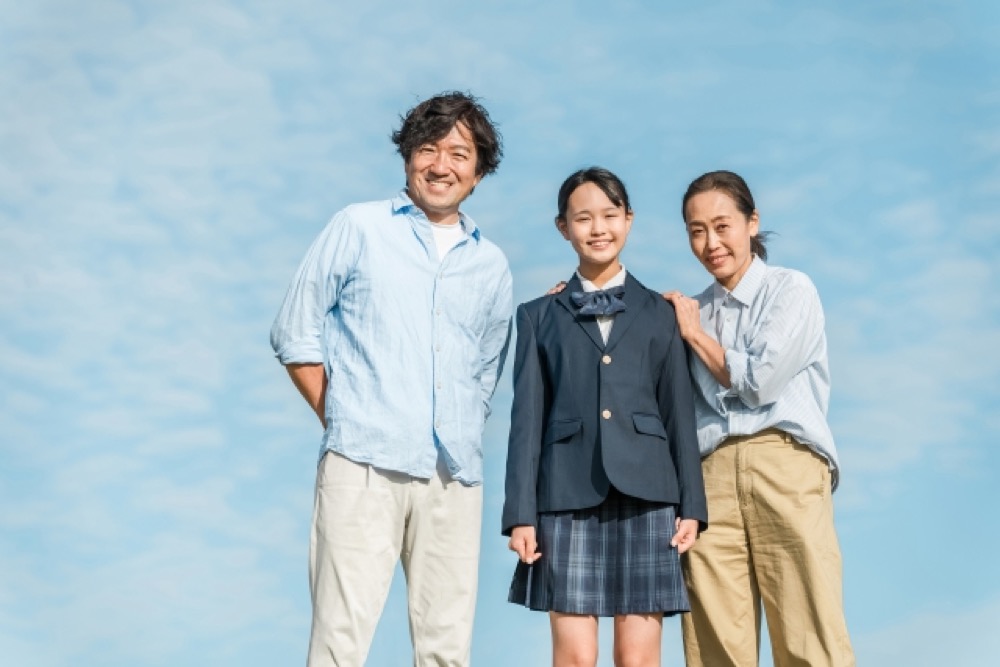 制服姿の娘と両親が並ぶ家族